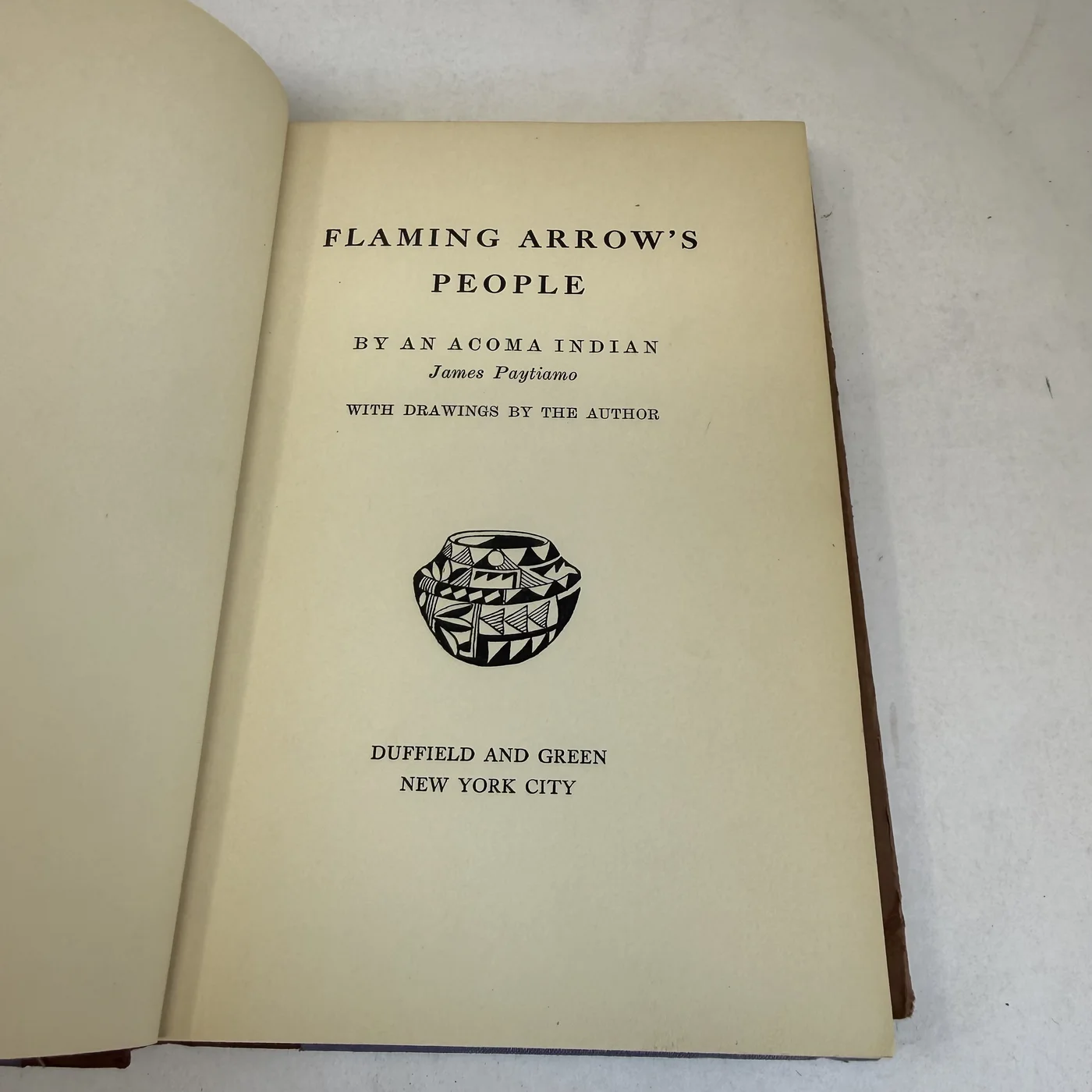 The title page: FLAMING ARROW'S PEOPLE / BY AN ACOMA INDIAN / James Paytiamo / WITH DRAWINGS BY THE AUTHOR, over a small black pottery ornament, with the imprint DUFFIELD AND GREEN, NEW YORK CITY.