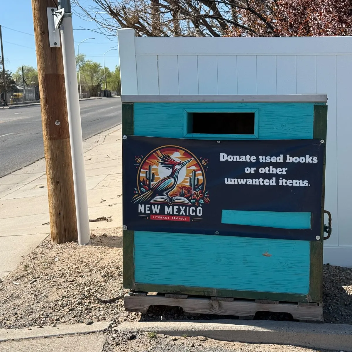 Free 24/7 book donation drop box at 5445 Edith Blvd NE, Unit A Albuquerque — turquoise outdoor box accepting used books, DVDs, and CDs anytime day or night