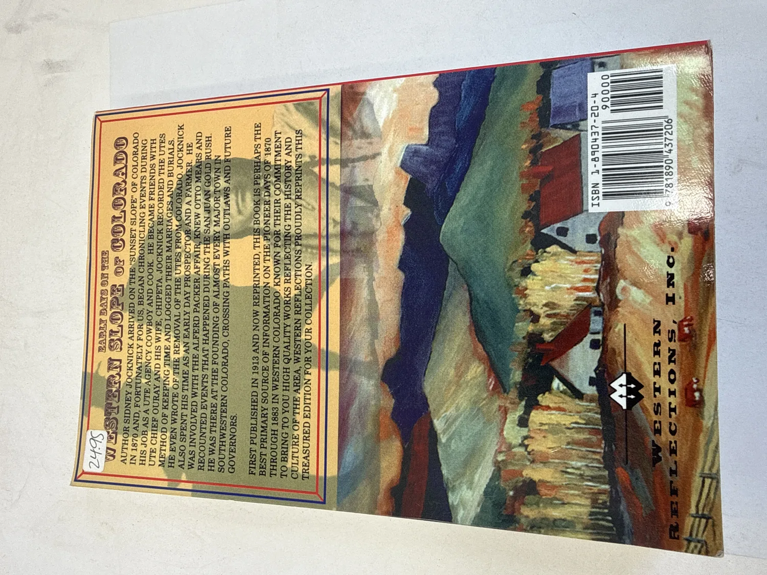 Back cover of Early Days on the Western Slope of Colorado by Sidney Jocknick showing description of Western Slope frontier life, Ute encounters, and early settlement. Western Reflections Publishing Company logo and barcode with ISBN 1-890437-20-4. Photographed at the New Mexico Literacy Project sorting desk in Albuquerque.
