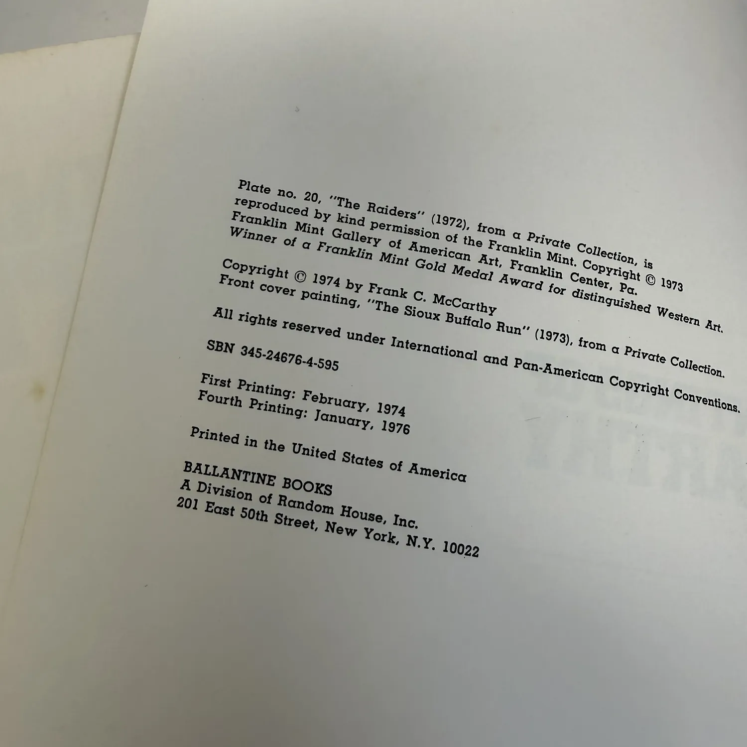 Copyright page of The Western Paintings of Frank C. McCarthy showing Franklin Mint Gold Medal plate, Copyright 1974 by Frank C. McCarthy, SBN 345-24676-4-595, First Printing February 1974, Fourth Printing January 1976, Ballantine Books A Division of Random House Inc 201 East 50th Street New York N.Y. 10022. Photographed at the New Mexico Literacy Project sorting desk in Albuquerque.