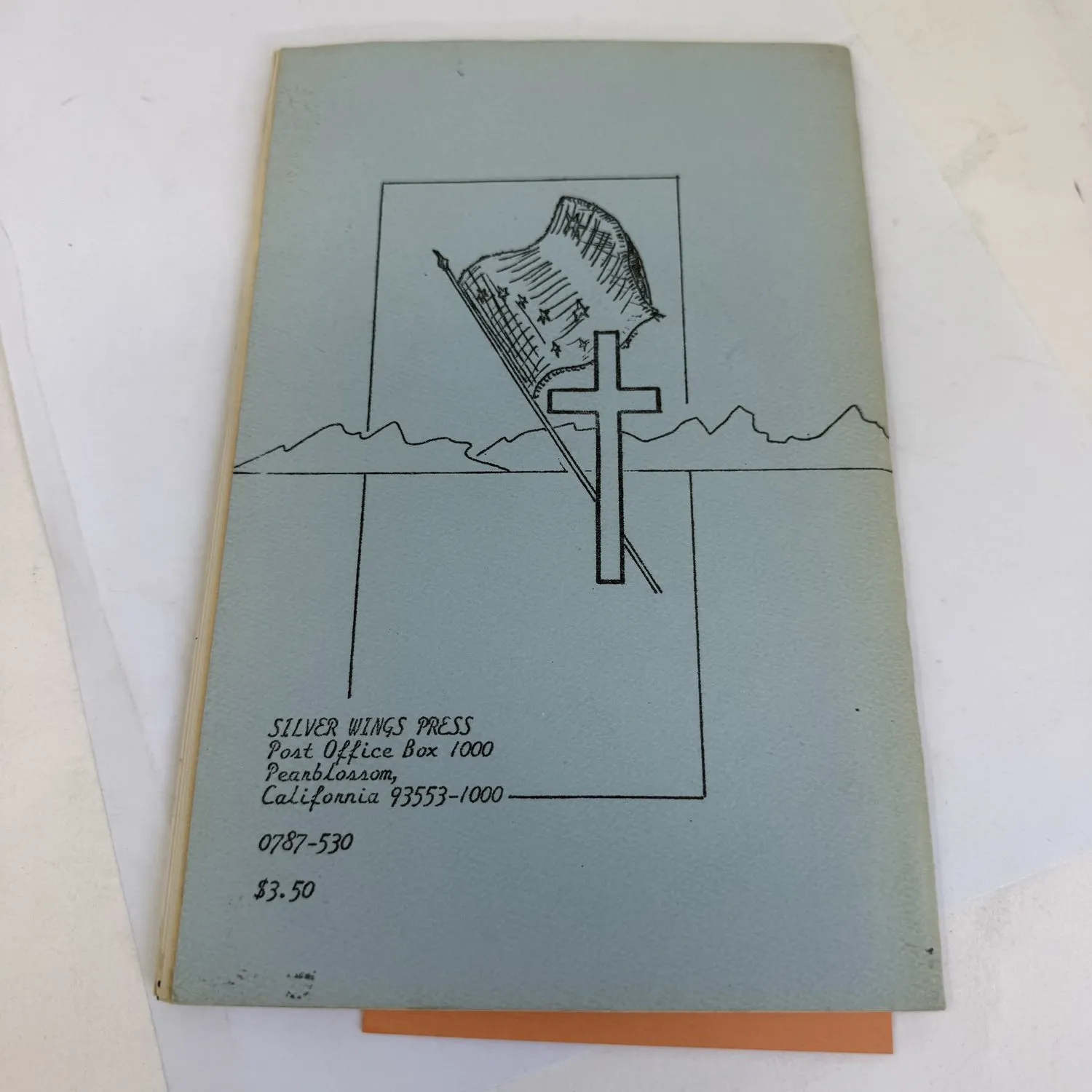 Back cover of I Breathe White by William T. Burke S.J., showing pen-and-ink illustration of an American flag and Christian cross with Silver Wings Press address in Pearblossom California. Alaska Jesuit poetry chapbook 1987.