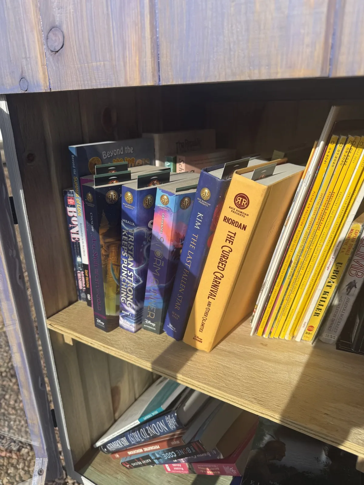 Little Free Library stocked with Rick Riordan Presents middle-grade hardcovers and a National Geographic magazine collection — Albuquerque North Valley