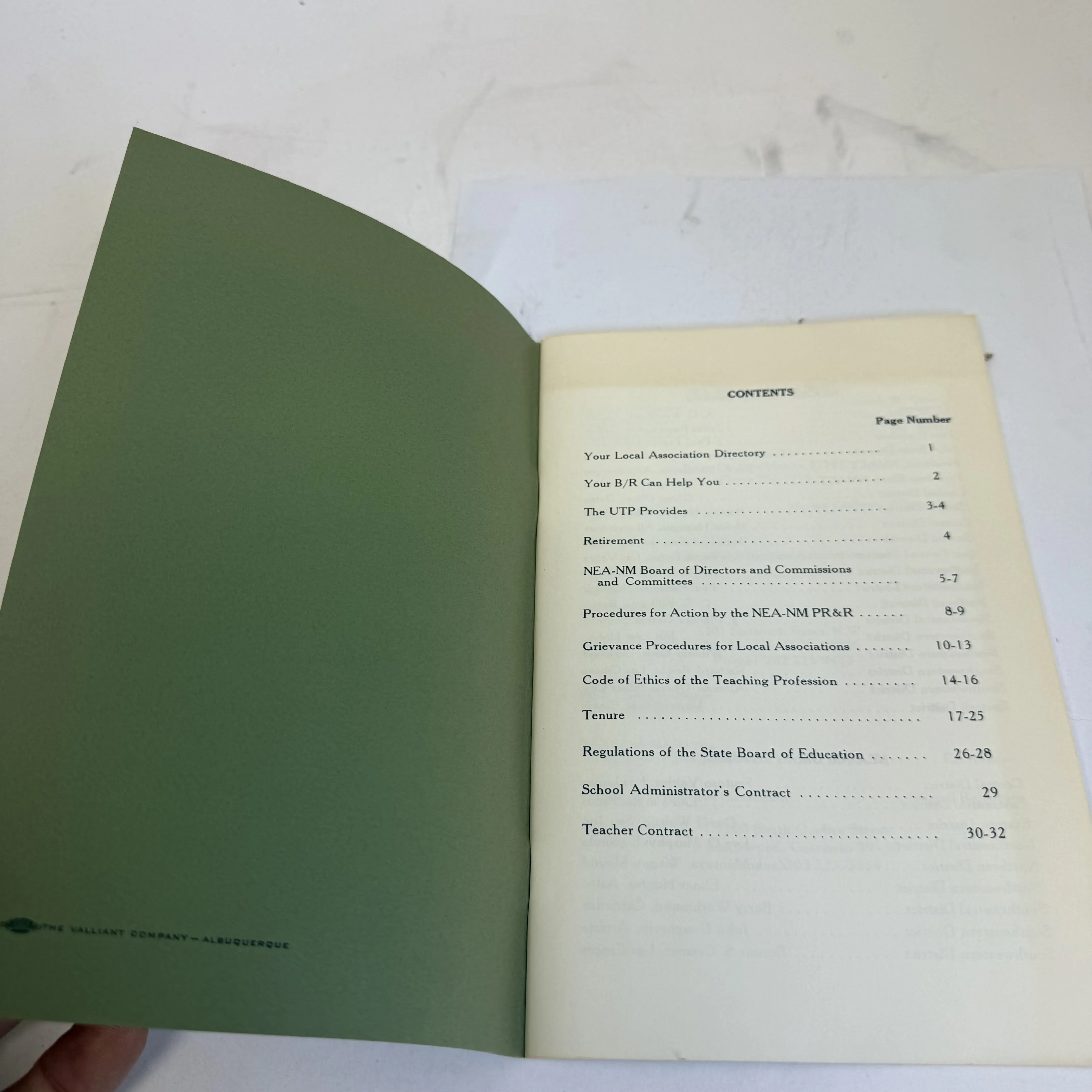 Inside front cover and table of contents of the NEA of New Mexico Member's Handbook showing Printed by The Valliant Company Albuquerque, with contents listing Local Association Directory, B/R Benefits, UTP Provisions, Retirement, Board of Directors, Grievance Procedures, Code of Ethics, Tenure, State Board Regulations, and Teacher Contract. Mid-century New Mexico teachers union institutional ephemera.