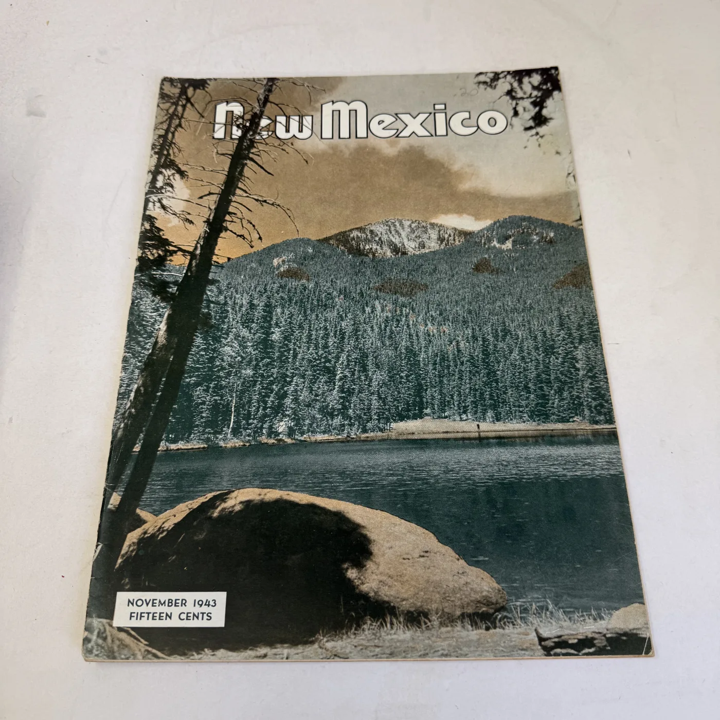 New Mexico Magazine November 1943 cover: mountain lake below a scree slope and pines, fifteen cents — photographed at New Mexico Literacy Project