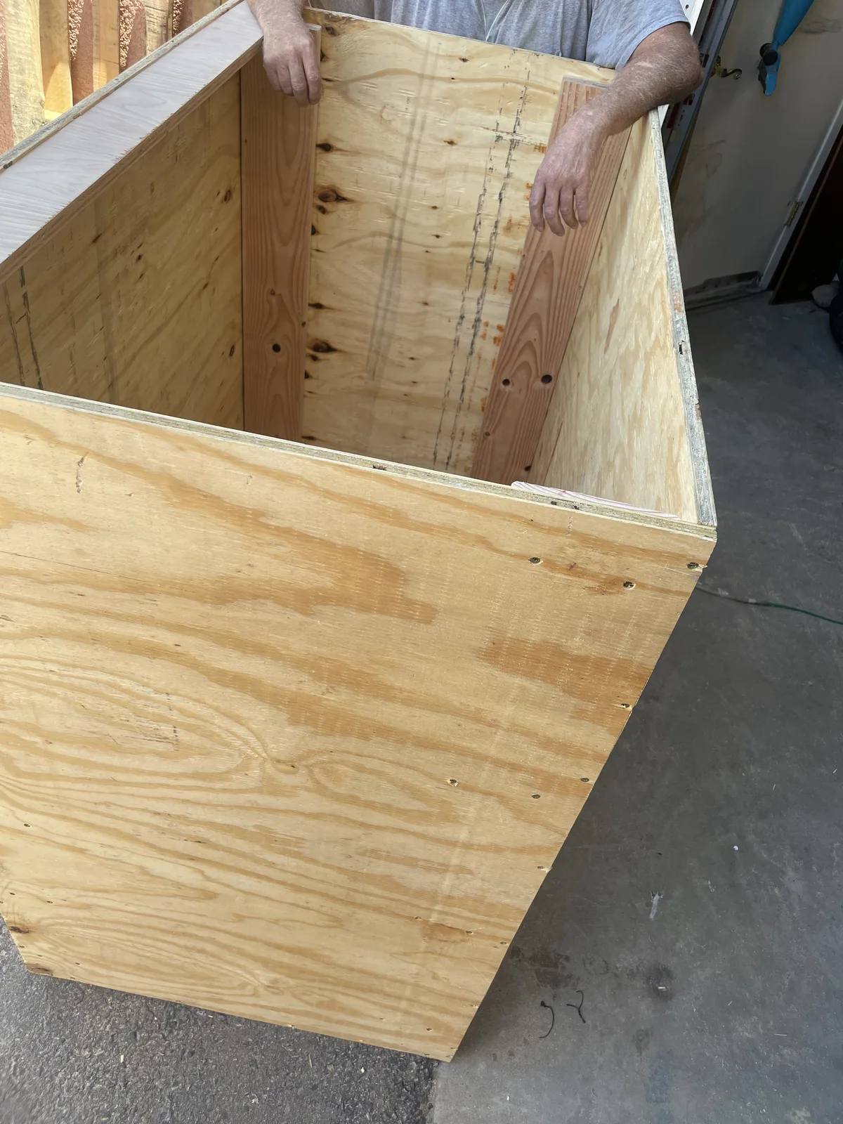 A plywood book drop box under construction, panels assembled and held upright before the chute is cut, New Mexico Literacy Project Albuquerque