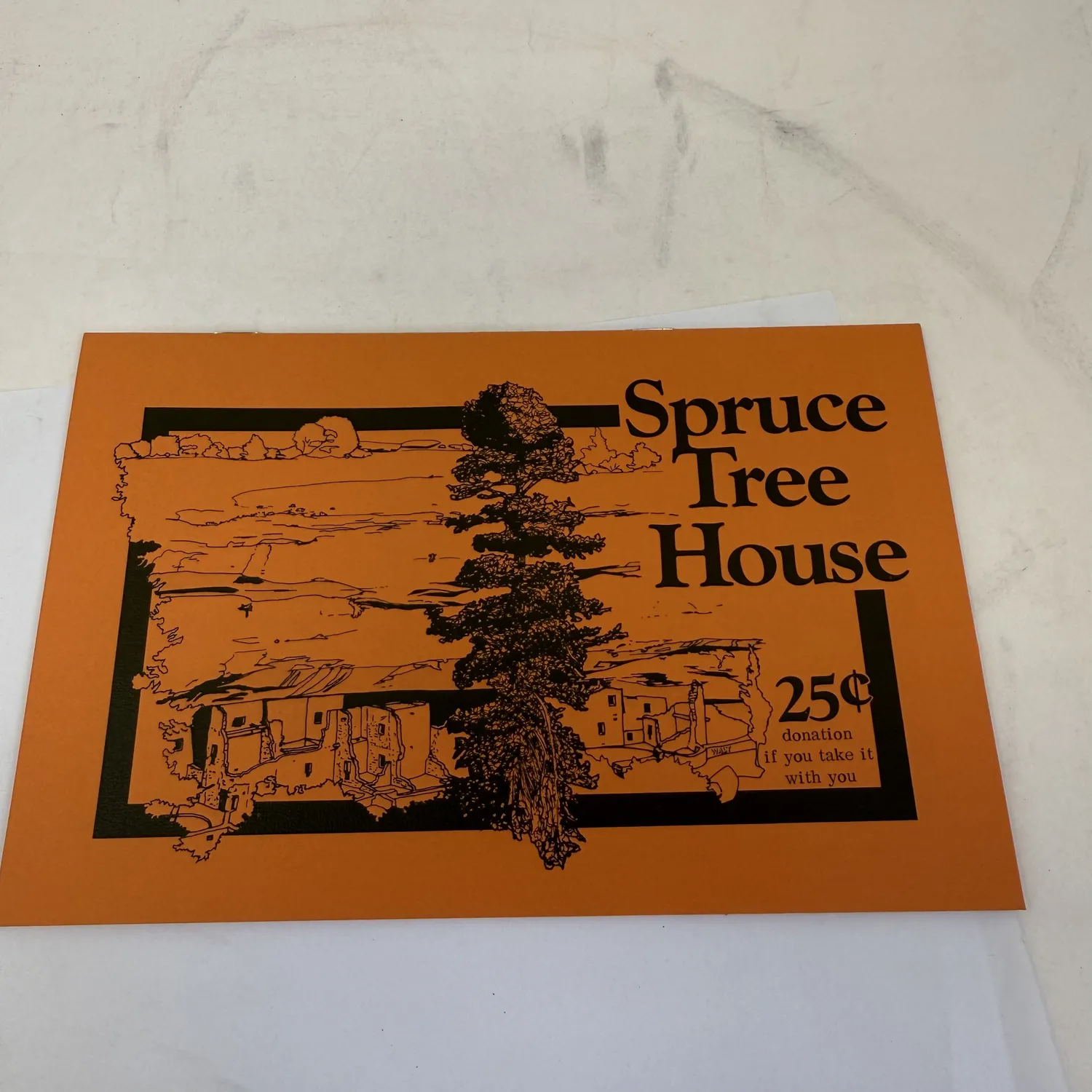 Vintage Spruce Tree House interpretive brochure from Mesa Verde National Park — orange card with black line illustration of the cliff dwelling and a tall spruce tree, 25 cents donation if you take it with you. Southwest National Park Service ephemera found in an Albuquerque estate donation to the New Mexico Literacy Project.