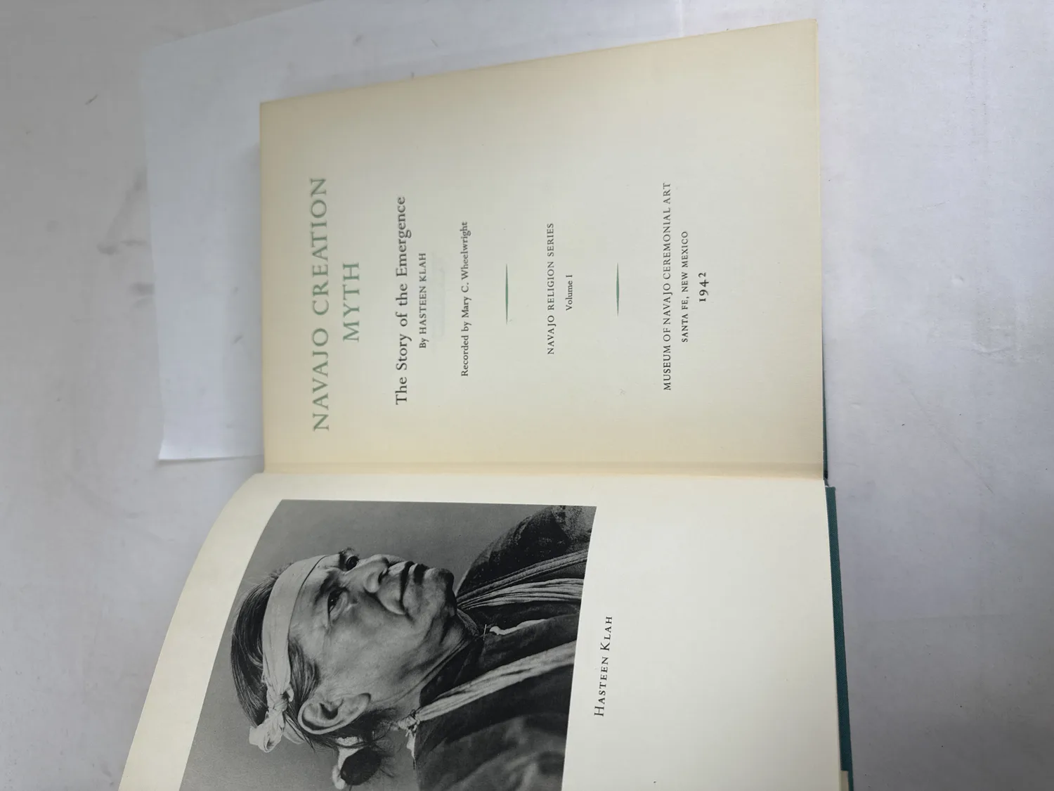 Title page of Navajo Creation Myth showing Hasteen Klah as author, Mary C. Wheelwright as recorder, Navajo Religion Series Volume I, Museum of Navajo Ceremonial Art Santa Fe New Mexico 1942, facing photographic frontispiece portrait of Hasteen Klah. Photographed at the New Mexico Literacy Project sorting desk in Albuquerque.