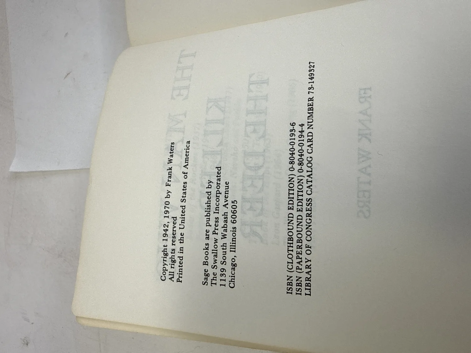 Copyright page of The Man Who Killed the Deer, Sage Books and Swallow Press edition showing Copyright 1942 and 1970 by Frank Waters, ISBN 0-8040-0193-6 clothbound edition, ISBN 0-8040-0194-4 paperbound edition, Library of Congress Catalog Card Number 73-149327. Photographed at the New Mexico Literacy Project sorting desk in Albuquerque.
