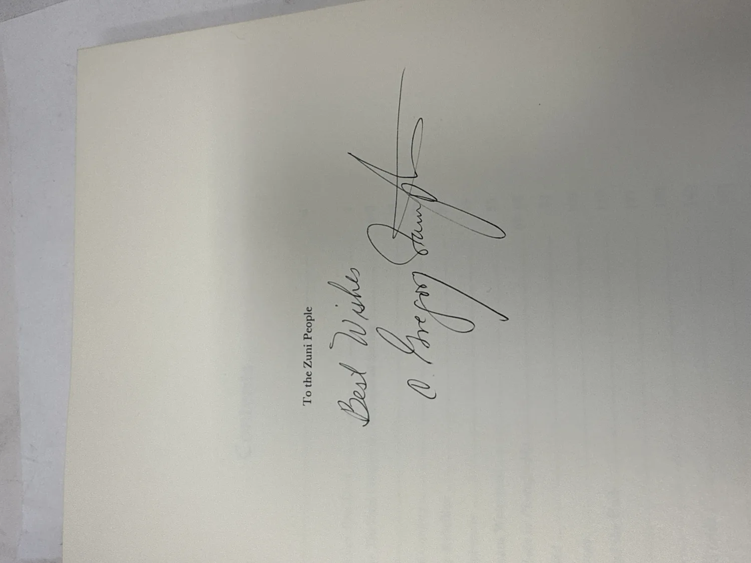Signed half-title page of The Zunis of Cibola showing the printed dedication To the Zuni People with author C. Gregory Crampton's inscription Best Wishes Gregory Crampton in ink. Photographed at the New Mexico Literacy Project sorting desk in Albuquerque.